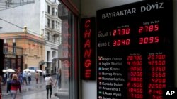 មនុស្ស​ម្នា​ដើរ​កាត់​ការិយាល័យ​ប្តូរប្រាក់​មួយ​កន្លែង​ក្នុង​ទីក្រុង​អ៊ីស្តង់ប៊ុល ប្រទេស​តួកគី កាលពីថ្ងៃទី៨ ខែមិថុនា ឆ្នាំ២០១៥។ តម្លៃរូបិប័ណ្ណ​តួកគី ធ្លាក់ចុះ​យ៉ាង​ខ្លាំង គឺនៅត្រឹម​​២.៨ ​បើធៀប​ទៅនឹង​ប្រាក់​ដុល្លារ​។​