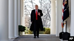 FILE - President Donald Trump waves as he walks through the Colonnade from the Oval Office of the White House, Jan. 25, 2019.