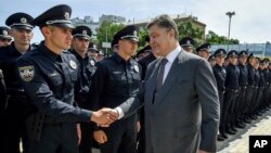 Ukrainian President Petro Poroshenko greets police officers at a swearing-in ceremony in Kyiv, Ukraine, July 4, 2015. 