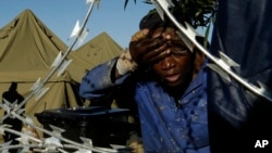 A man washes his face outside a shelter for displaced foreigners in east of Johannesburg, South Africa, April 21, 2015. 