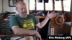  Fisherman Mike Hudson sits in the cabinet of his boat and talks about his most recent small catch of salmon at the Berkeley, Calif., Marina on Thursday, July 22, 2021.(AP Photo/Eric Risberg)
