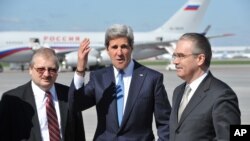 Menlu AS John Kerry (tengah) disambut Yuri Filatov, staf protokoler Kemenrian Luar Negeri Rusia (kanan) dan Alexandr Darchiyev, Staf Khusus Amerika Utara Kementerian Luar Negeri Rusia setibanya di Bandara Vnukovo, Moskow (7/5). 