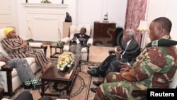 President Robert Mugabe, center, in a meeting with the ZDF Commander General Constantino Chiwenga, South African Minister of Defense Nosiviwe Mapisa-Nqakula (in yellow head wear), Zimbabwe Defense Minister Dr Sydney Sekeramayi and Zimbabwe State Security Minister Cde Kembo Mohadi at State House in Harare, Zimbabwe, Nov. 16, 2017. 