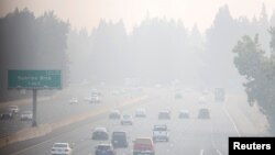 Mobil melaju di sepanjang Highway 50 di tengah kepungan asap tebal akibat kebakaran hutan "Caldor Fire" di Sacramento, California, 28 Agustus 2021. (REUTERS/Fred Greaves)