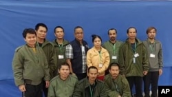 在泰国外交部提供的这张照片中，2023年11月24日星期五，10名被释放的泰国人质和一名军官(左四)在合影。（美联社）