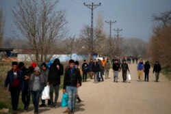 FILE - Migrants walk in Edirne at the Turkish-Greek border, March 9, 2020.