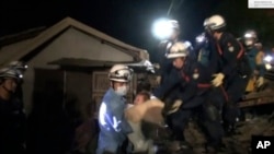 In this image made from video and provided by Kumamoto Prefectural Police, eight-month-old baby Miku Nishimura is carried away after being rescued from her home, which collapsed in the magnitude-6.5 earthquake.