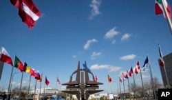 FILE - Flags of the NATO nations fly outside NATO headquarters in Brussels.