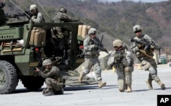 FILE - U.S. Army and South Korean soldiers take their positions during a demonstration of the combined arms live-fire exercises at the Rodriquez Multi-Purpose Range Complex in Pocheon, north of Seoul, South Korea, March 25, 2015.