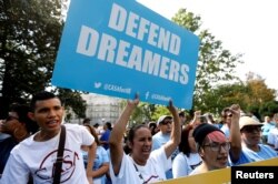 A woman holds a sign during a rally calling for the passage of a clean Dream Act outside the U.S. Capitol in Washington, Sept. 26, 2017.