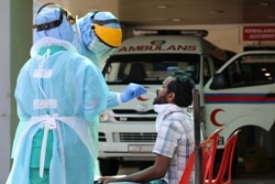 Health workers perform testing at coronavirus disease (COVID-19) testing center at KPJ Damansara Hospital, in Petaling Jaya, Malaysia, March 28, 2020.