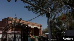 Bendera nasional China berkibar di luar bekas Masjid Xinqu yang kubah dan menaranya sudah dibongkar, di Changji, di luar Urumqi, Xinjiang, Uighur, China, 6 Mei 2021. (Foto: Thomas Peter/Reuters)