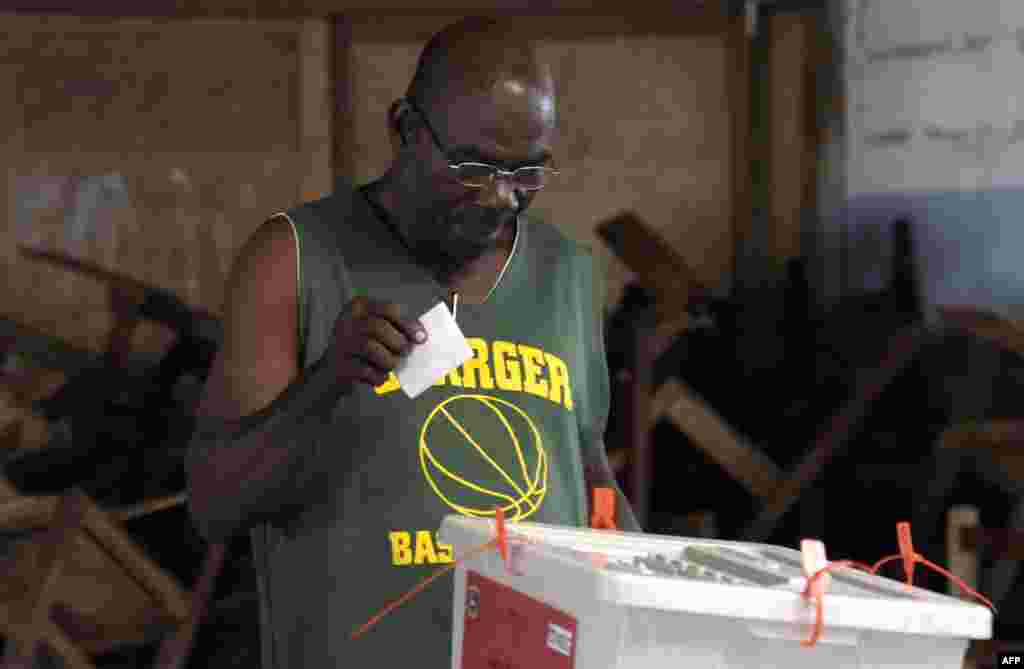 Un électeur libérien met son bulletin de vote dans une boîte à un bureau de vote, à Monrovia, le 26 décembre 2017.