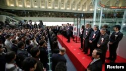 Japanese Prime Minister Shinzo Abe (C) on the podium, speaks during a ceremony to wrap up the year's trading on the Tokyo Stock Exchange in Tokyo, Dec. 30, 2013.
