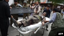 Seorang pria Afghanistan dibawa ke sebuah rumah sakit milik LSM yang didanai Italia sementara pasukan keamanan Afghanistan menghadapi serangan dari militant Taliban di sebuah kompleks tempat kantor-kantor organisasi Internasional di Kabul, 8 Mei 2019.
