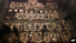 FILE - An aerial file photo shows the remains of residences leveled by the Camp wildfire in Paradise, Calif., Nov. 15, 2018.
