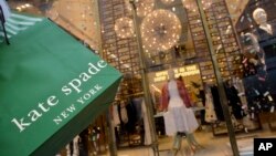 A woman carries her Kate Spade shopping bag outside the fashion designer's Madison Avenue store in New York, June 5, 2018.