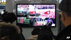 People watch a TV news showing file footage of a North Korean rocket carried during a military parade, at Seoul Railway Station in Seoul, South Korea, January 24, 2013.