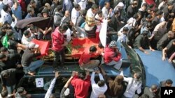 A funeral procession for Ali Abdulhadi Mushaima, 21, who was killed in clashes Monday in nationwide anti-government protests, moves slowly through the streets of Jidhafs, Bahrain, February 15, 2011