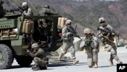 FILE - U.S. Army and South Korean soldiers take their positions during a live-fire exercise at the Rodriquez Multi-Purpose Range Complex in Pocheon, north of Seoul, South Korea, March 25, 2015. 