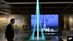A man walks past a model of the Tower Project at Dubai Creek Harbour Development designed by Spanish-Swiss architect Santiago Calatrava Valls, in Dubai, United Arab Emirates, April 10, 2016. 