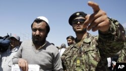 سرباز افغان یک توقیف شدۀ زندان بگرام را حین رهایی از این توقیفگاه کمک و رهنمایی می کند.