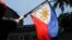 FILE - A protester waves a Philippine flag during a rally outside the Department of Foreign Affairs in Manila, Philippines on Friday, June 21, 2019.