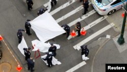 New York Police Department officers prepare to cover a body after a shooting in midtown Manhattan in New York, U.S., May 18, 2016.