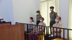 This handout photo taken on May 24, 2021 and released by Myanmar's Ministry of Information on May 26 shows detained civilian leader Aung San Suu Kyi (L) and detained president Win Myint (C) during their first court appearance in Naypyidaw