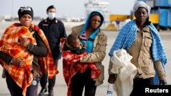 Migrants disembarks from Dattilo coast guard vessel in the Sicilian harbor of Augusta, Italy, Feb. 25, 2017.