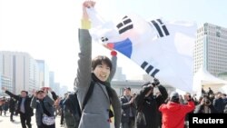 People react to the decision of the Constitutional Court over the impeachment of South Koeran President Park Geun-hye in Seoul, South Korea, March 10, 2017.