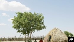 Two Basarwa women hide from the scorching sun in Metsiamenong, a remote village in the heart of the Central Kalahari Game Reserve, Botswana. (2007 file photo)