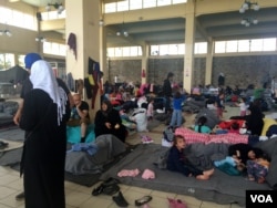 While most people camped out on Athens' Piraeus port sleep in plastic tents outside, some families with small children bunk in this port station, in increasingly unsanitary conditions in Athens, Greece on April, 8, 2016. (H. Murdock / VOA)