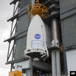 The Mars Science Laboratory, bolted inside the payload fairing of an Atlas V rocket, is hoisted into place at Launch Complex 41 at Cape Canaveral Air Force Station in Florida.