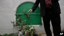 FILE - A man stands in front of the grave of Soheir al-Batea, who died after undergoing female genital mutilation, in Dierb Biqtaris village on the outskirts of Aga, Egypt, Nov. 5, 2014.