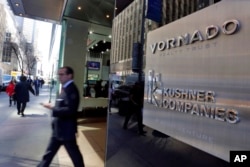 FILE - A man walks out of the 666 Fifth Avenue office tower owned by the Kushner Cos., the real estate company run by the family of Jared Kushner, in New York, March 29, 2017.