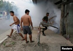 FILE - A Bolivian soldier fumigates a slum to prevent dengue in Villa Tunari in the Chapare region, some 310 km east of La Paz, October 10, 2014.