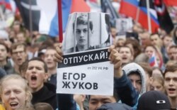 FILE - A supporter of blogger Yegor Zhukov, who was detained during an earlier protest for fair elections, holds a placard during a rally to demand authorities allow opposition candidates to run in local elections in Moscow, Aug. 10, 2019.