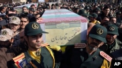 FILE - Civilians and armed forces members carry the flag-draped coffins of Iranian Revolutionary Guard Gen. Mohsen Ghajarian, foreground, and five soldiers who were killed in fighting in Syria, during their funeral outside the headquarters of the guard's ground forces, in Tehran, Iran, Feb. 6, 2016.