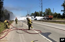 Photo made available by the Chatham Emergency Services, GA., shows firefighters putting out a fire caused by a plane crash near the airport in Savannah, Ga., May 2, 2018.