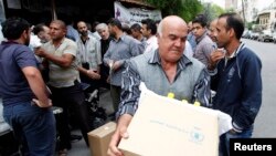 Para pengungsi Suriah menerima bantuan pangan PBB di Damaskus tahun lalu (foto: dok).