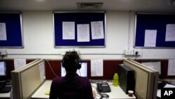 FILE - An Indian woman takes calls on a government hotline established in an effort to confront the country's treatment of women, Dec. 2, 2013.