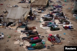FILE - Ethiopian migrants sleep out in the open near a transit center where they wait to be repatriated, in the western Yemeni town of Haradh, on the border with Saudi Arabia, May 21, 2013.