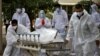 Petugas menarik tandu yang membawa korban yang meninggal karena COVID-19 ke kamar mayat di Ahmedabad, India, 8 Mei 2021. (REUTERS / Amit Dave)