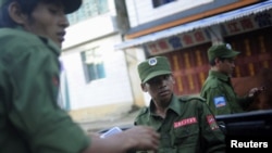 FILE - Armed soldiers from the United Wa State Army ride in a vehicle on a street in Namteuk, neighboring China's border town of Mangka, in Myanmar's Wa State Sept. 3, 2009.
