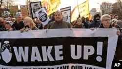 اعتراض کنندگان لوحه های را حمل می کردند که در آن نوشته شده بود "بیدار شوید"