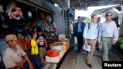 U.S. Secretary of State John Kerry (R) visits the village of Kien Vang along the Mekong River Delta, Vietnam, Dec. 15, 2013.