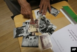 Lee Soo-nam, 76, explains the photos showing his family members during an interview at his home in Seoul, South Korea, Aug. 17, 2018. Lee is among about 200 war-separated South Koreans and their family members who are crossing into North Korea for heart-wrenching meetings with relatives they haven’t seen for decades.