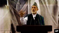 Afghan President Hamid Karzai, center, speaks during a ceremony honoring the late Commander Ahmad Shah Massoud, a beloved anti-Taliban fighter who was assassinated 13 years ago, in Kabul, Afghanistan, Sept. 9, 2014. 