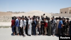 FILE - A group of alleged Islamic State members, pardoned by the Civil Council of Raqqa, are seen during an earlier pardoning ceremony in Ain Issa village, north of Raqqa, Syria, June 24, 2017.